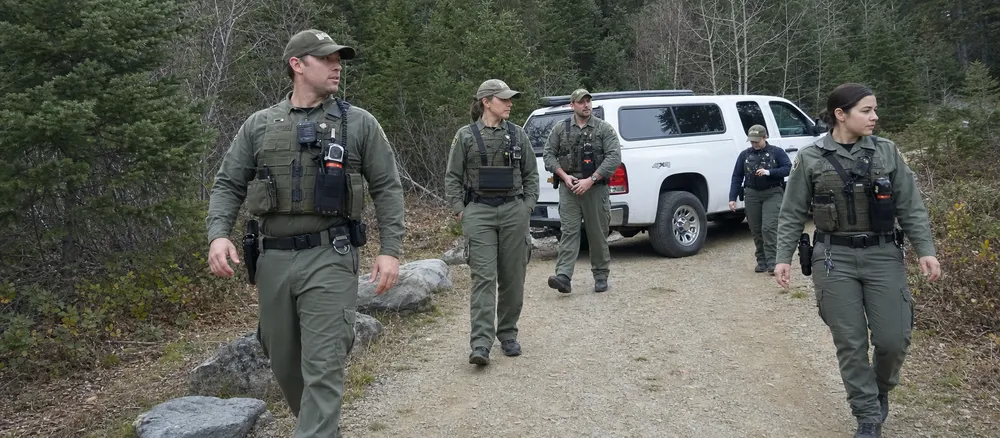 Park service field staff carrying bear spray in chest holsters as part of institutional procurement program