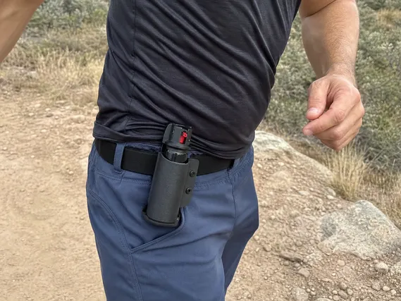 Bear spray running holster mounted on belt loop, front hip position