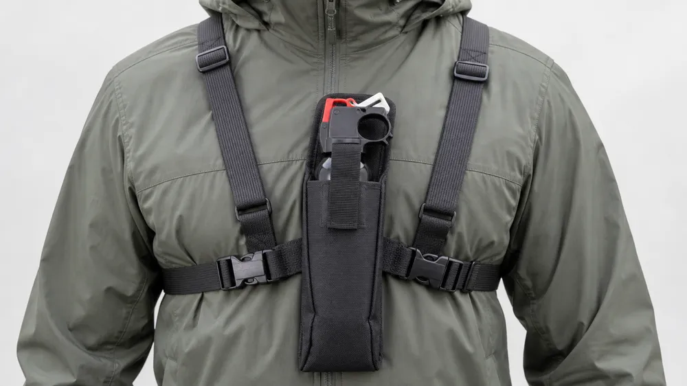 Bear spray chest holster — bilateral strap system, thumb-release buckle, sternum-height carry