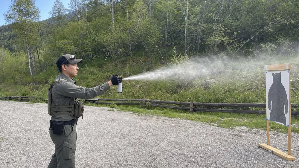 Wildlife ranger practicing bear spray deployment with inert training canister